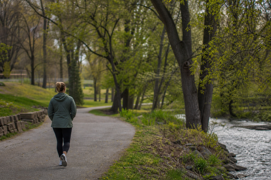 Person taking a quiet solo walk in a park for emotional recovery